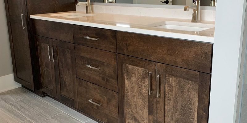 A bathroom vanity with two sinks and a mirror.