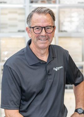 A man wearing glasses and a black shirt is posing for a picture.