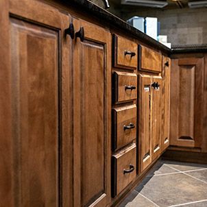 A kitchen with wooden cabinets and drawers and a granite counter top.