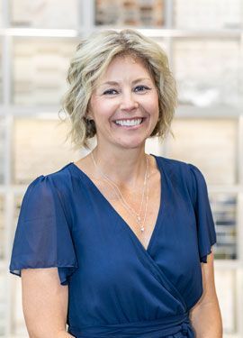 A woman in a blue dress is smiling for the camera.