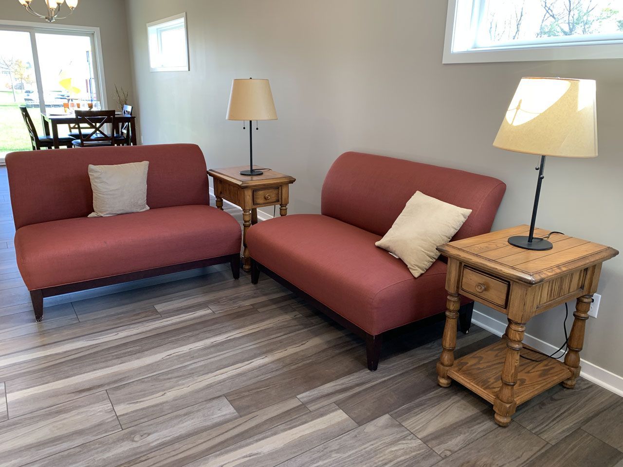 A living room with two red couches and two lamps