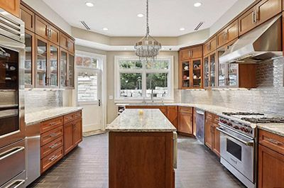 A large kitchen with stainless steel appliances and wooden cabinets.