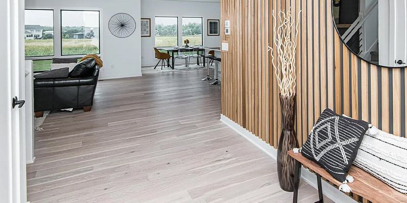 A hallway in a house with a wooden wall and a bench.