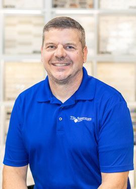 A man wearing a blue polo shirt is smiling for the camera.