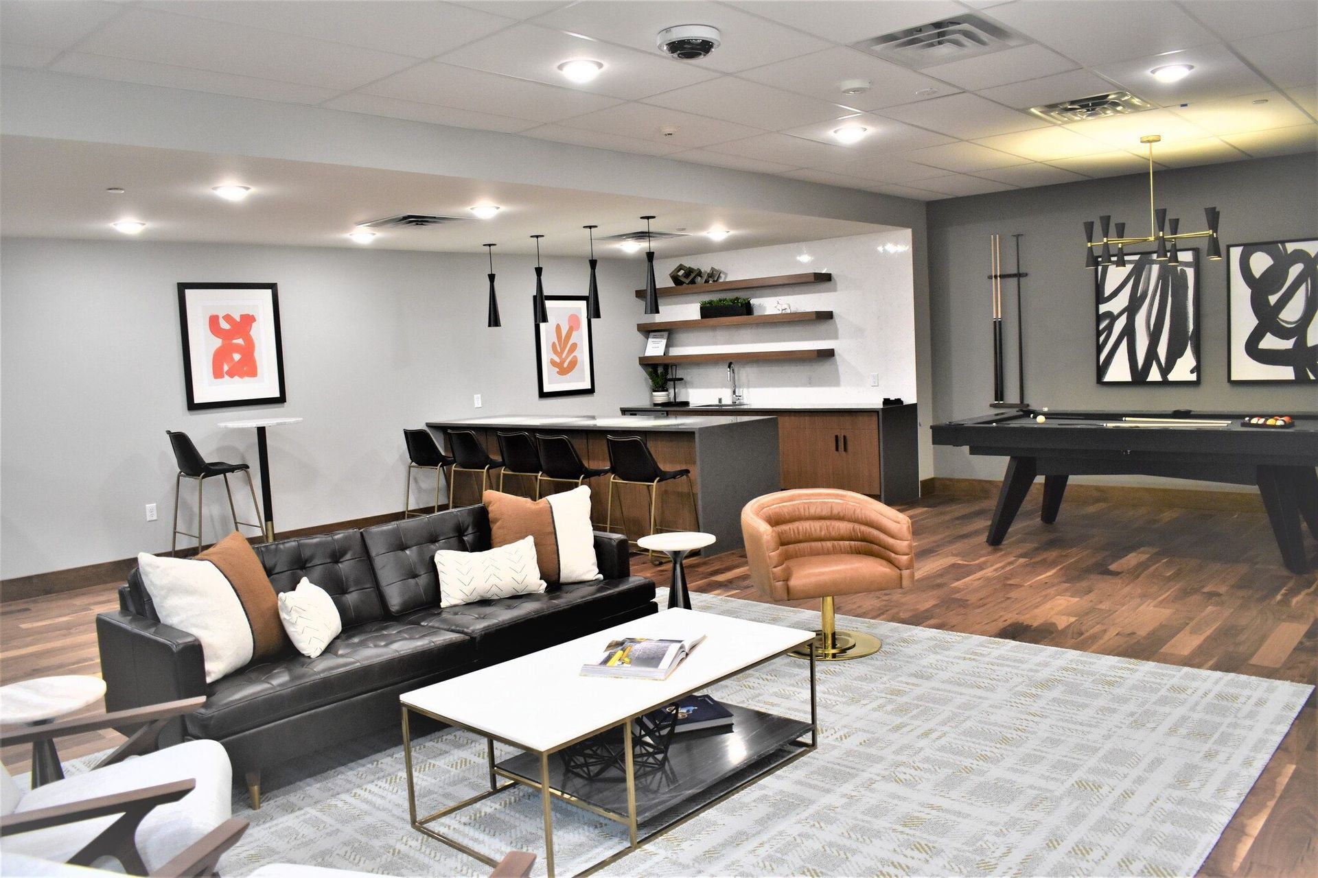Spacious community lounge with sofa seating, a bar area, and a pool/billiards table.