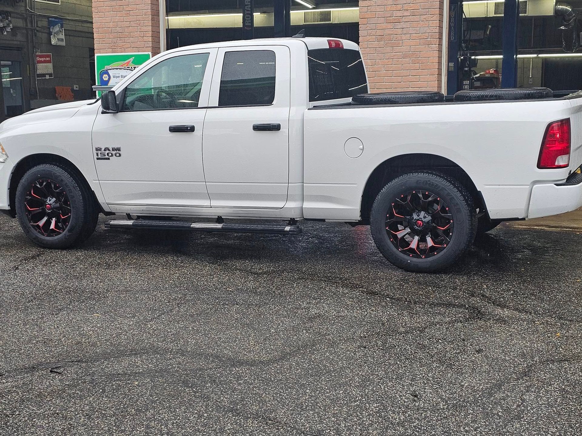 A white dodge ram truck is parked in a gravel lot.