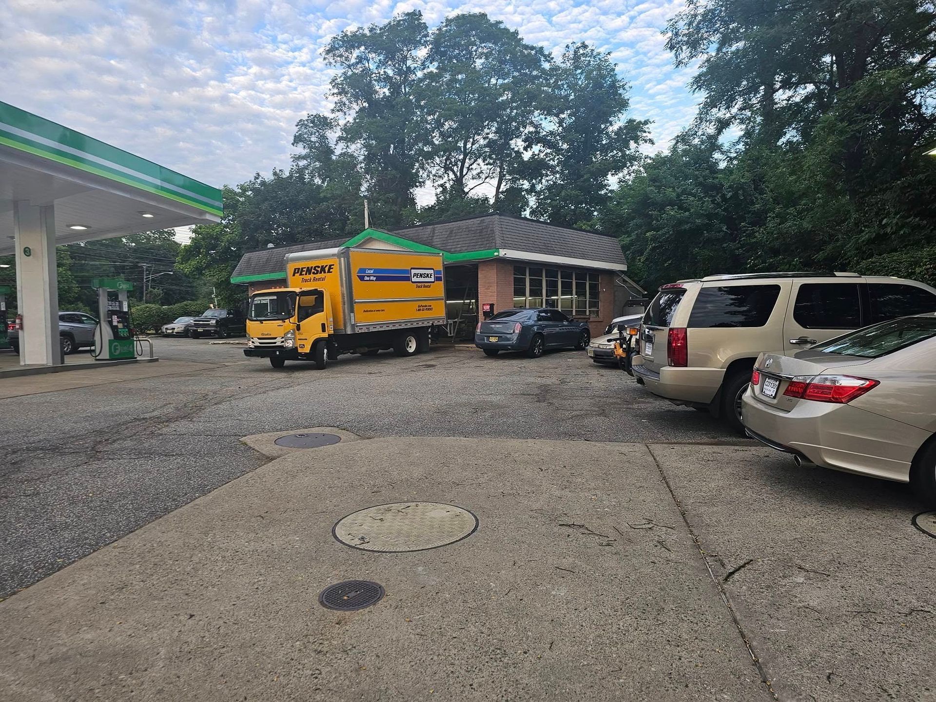 A lot of cars are parked in front of a gas station.