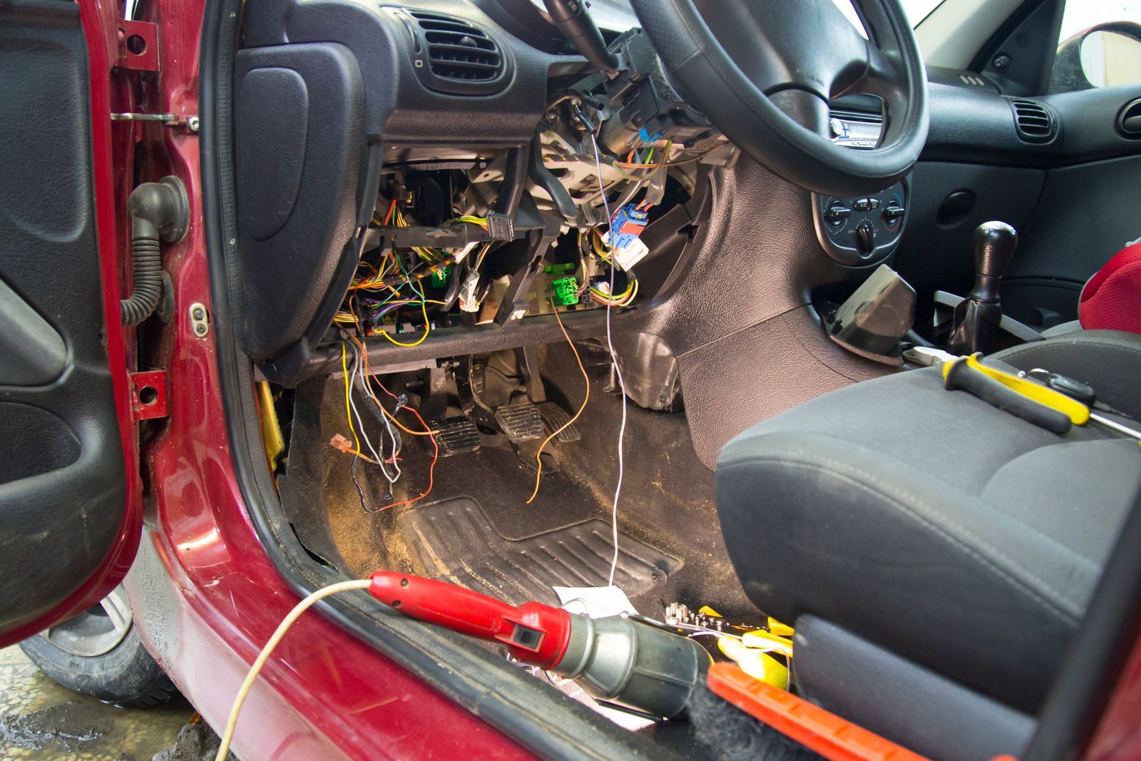 The inside of a red car is being worked on