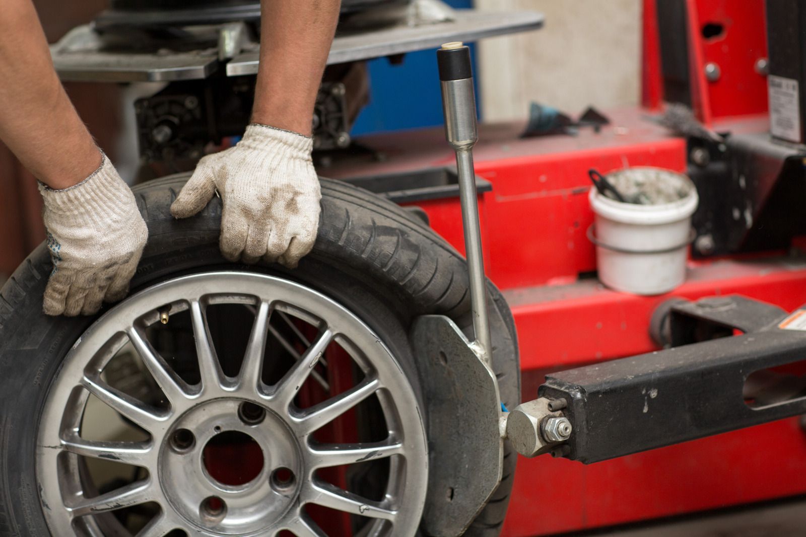 A person is changing a tire on a machine.
