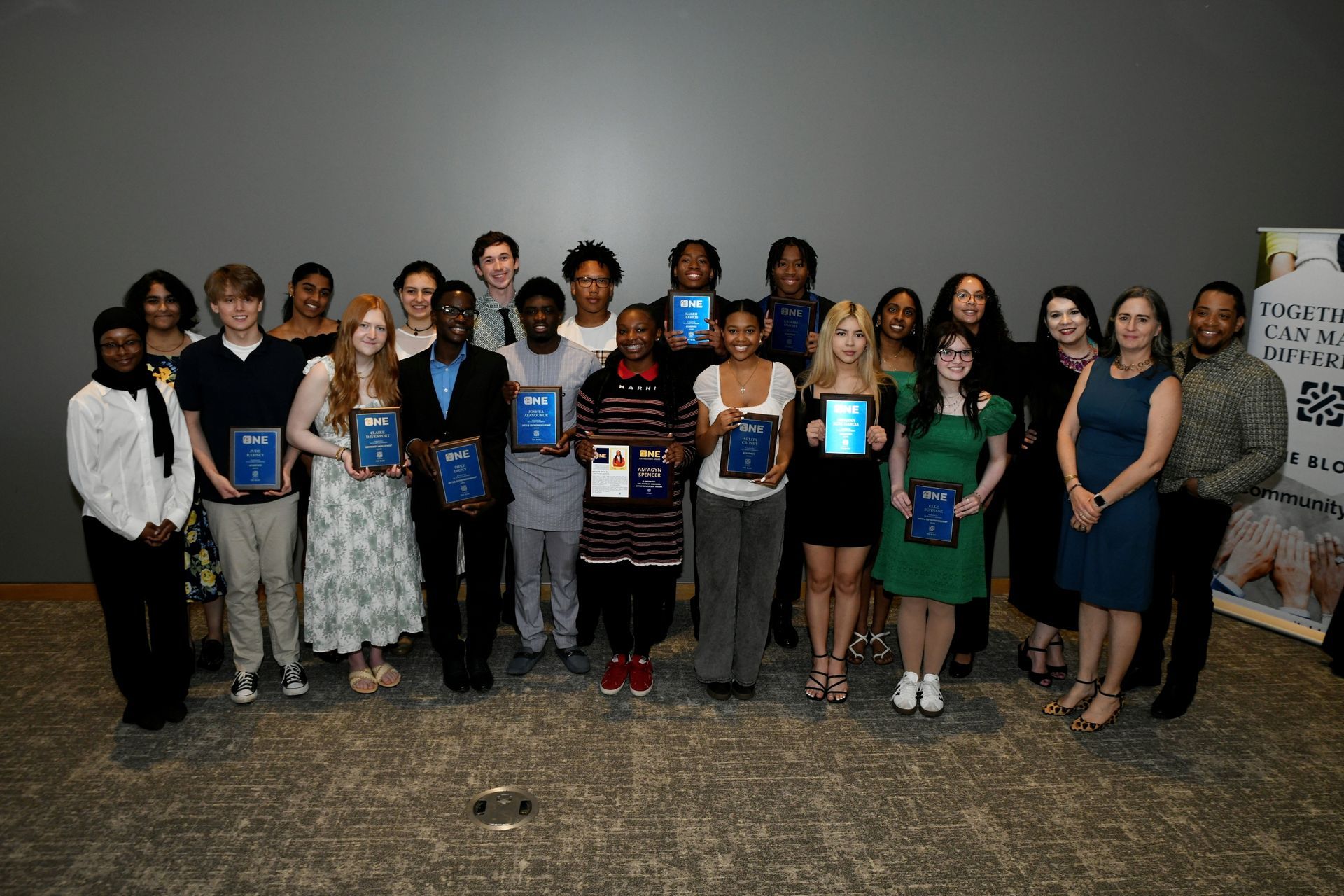 A group of people are posing for a picture holding plaques