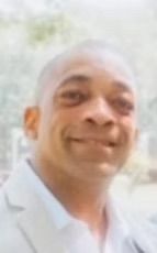 A man is smiling for the camera in a blurry photo.