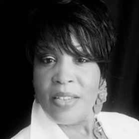 A black and white photo of a woman wearing a white shirt and earrings.