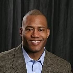 A man in a suit and tie is smiling for the camera.