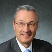 A man in a suit and tie is smiling for the camera.