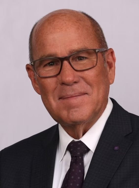 A bald man wearing glasses and a suit and tie
