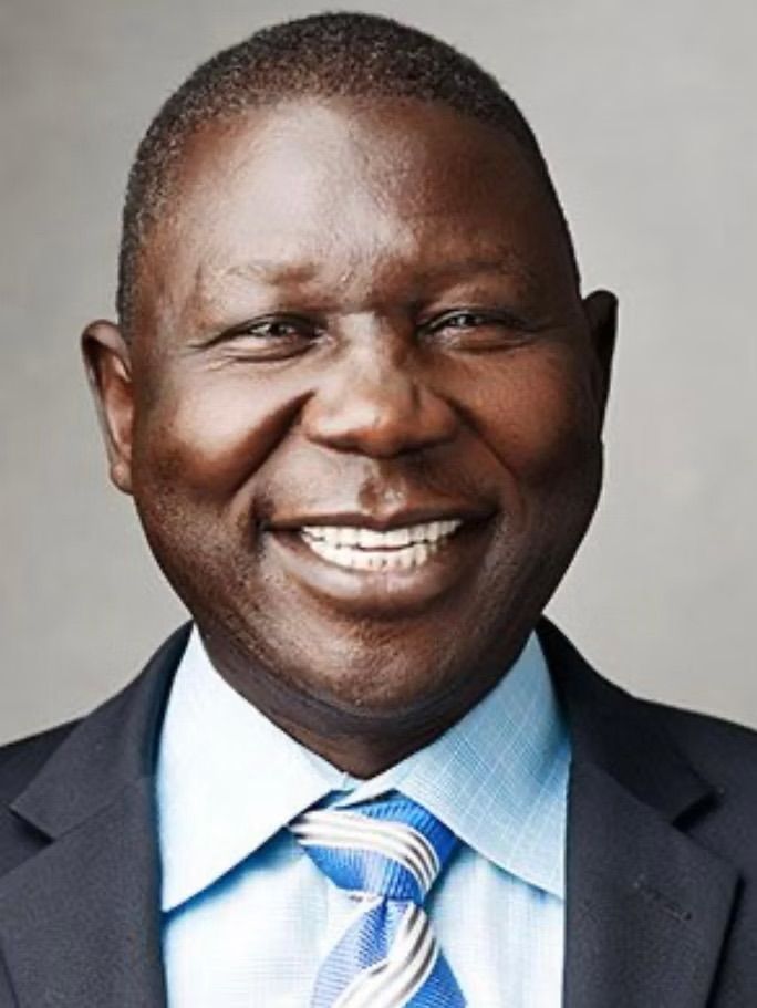 A man in a suit and tie is smiling for the camera