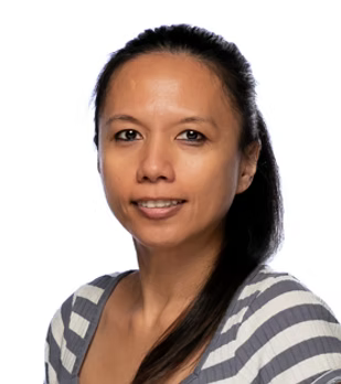 A woman in a striped shirt is smiling for the camera.