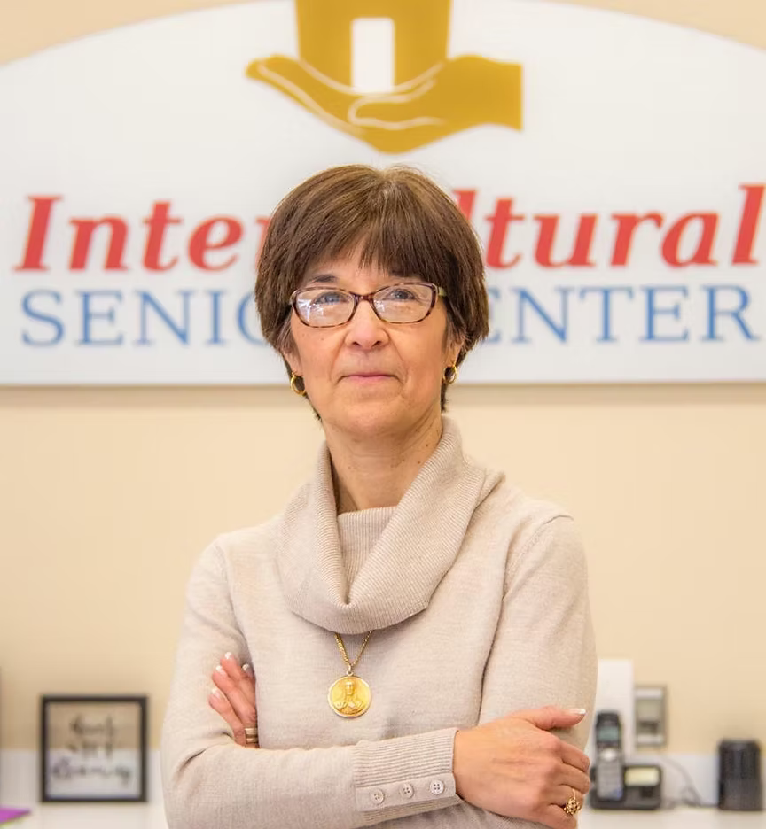 A woman is standing in front of a sign that says inter natural senior center