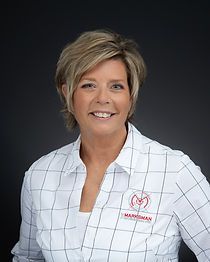 A woman in a plaid shirt is smiling for the camera.