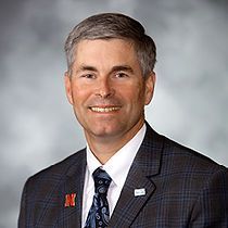 A man in a suit and tie is smiling for the camera.