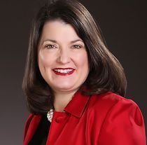 A woman is wearing a red jacket and smiling for the camera.