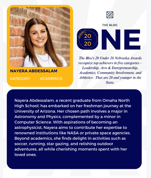 A woman is standing in front of a brick wall.