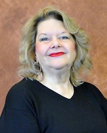 A woman wearing a black shirt and red lipstick is smiling for the camera.