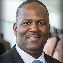 A man in a suit and tie is smiling for the camera.