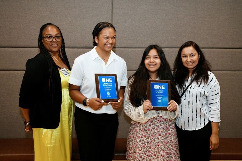 A group of women are holding plaques that say bhe