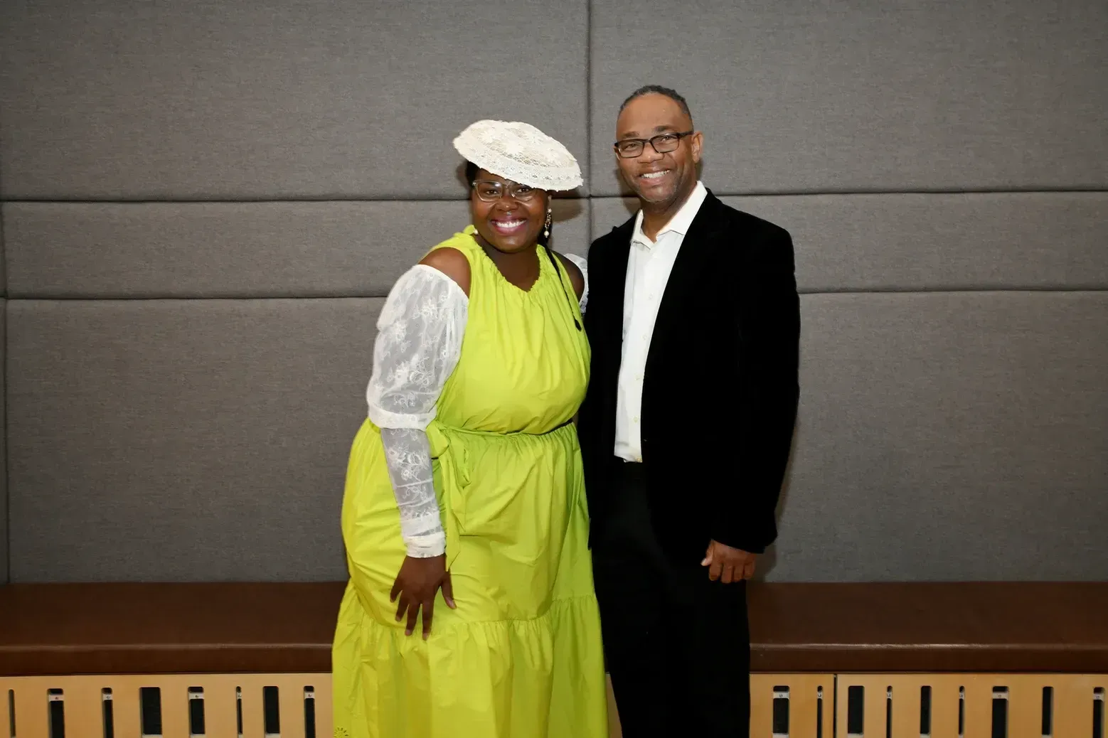 A man and a woman are posing for a picture . the woman is wearing a yellow dress.