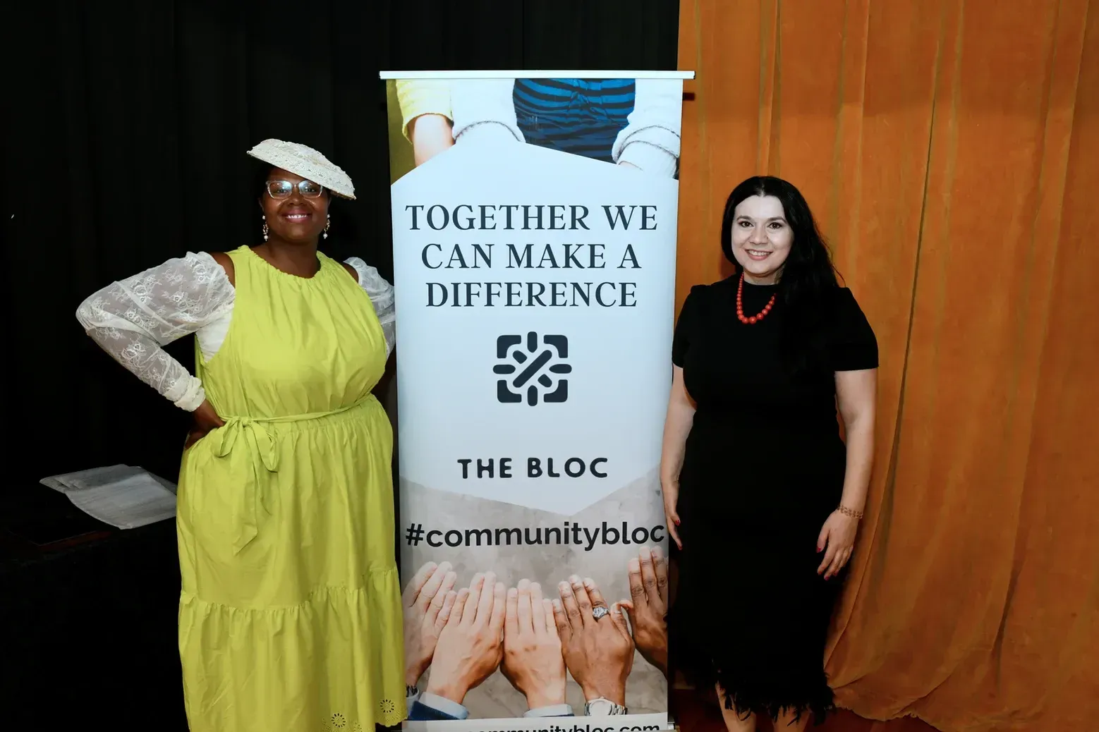 Two women are standing next to a banner that says `` together we can make a difference ''.