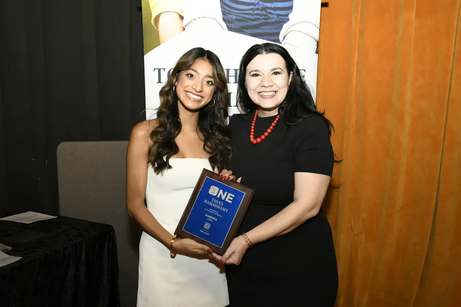 Two women are standing next to each other holding a plaque.