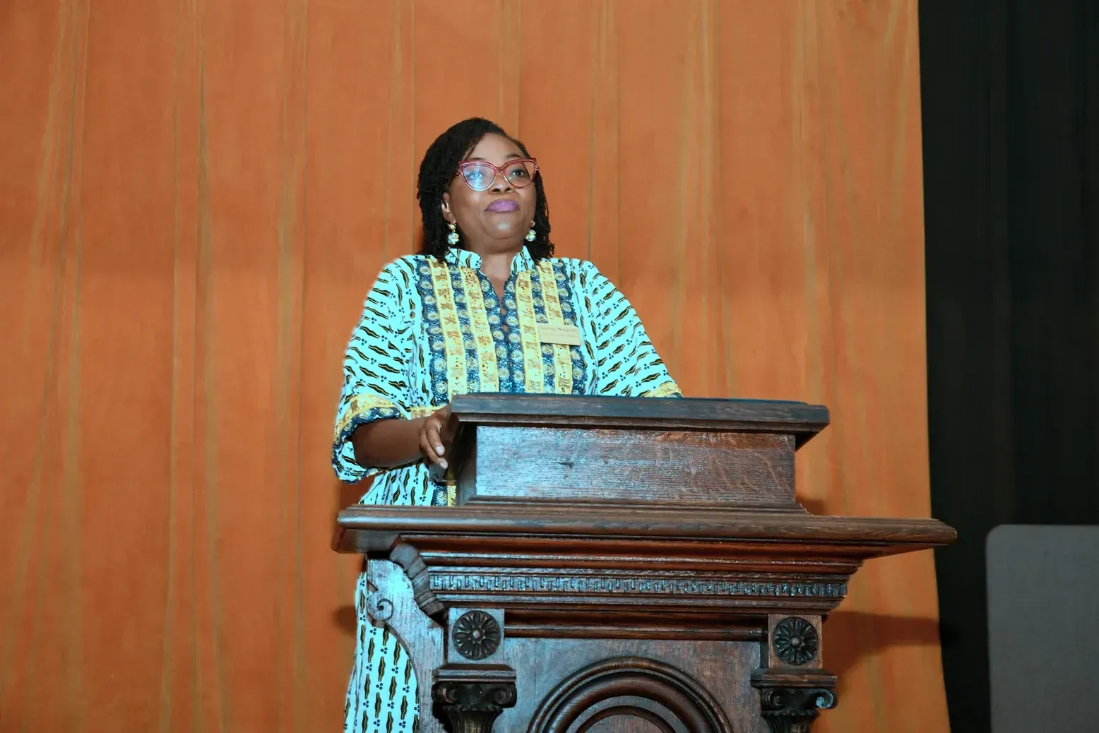 A woman is standing at a podium giving a speech.