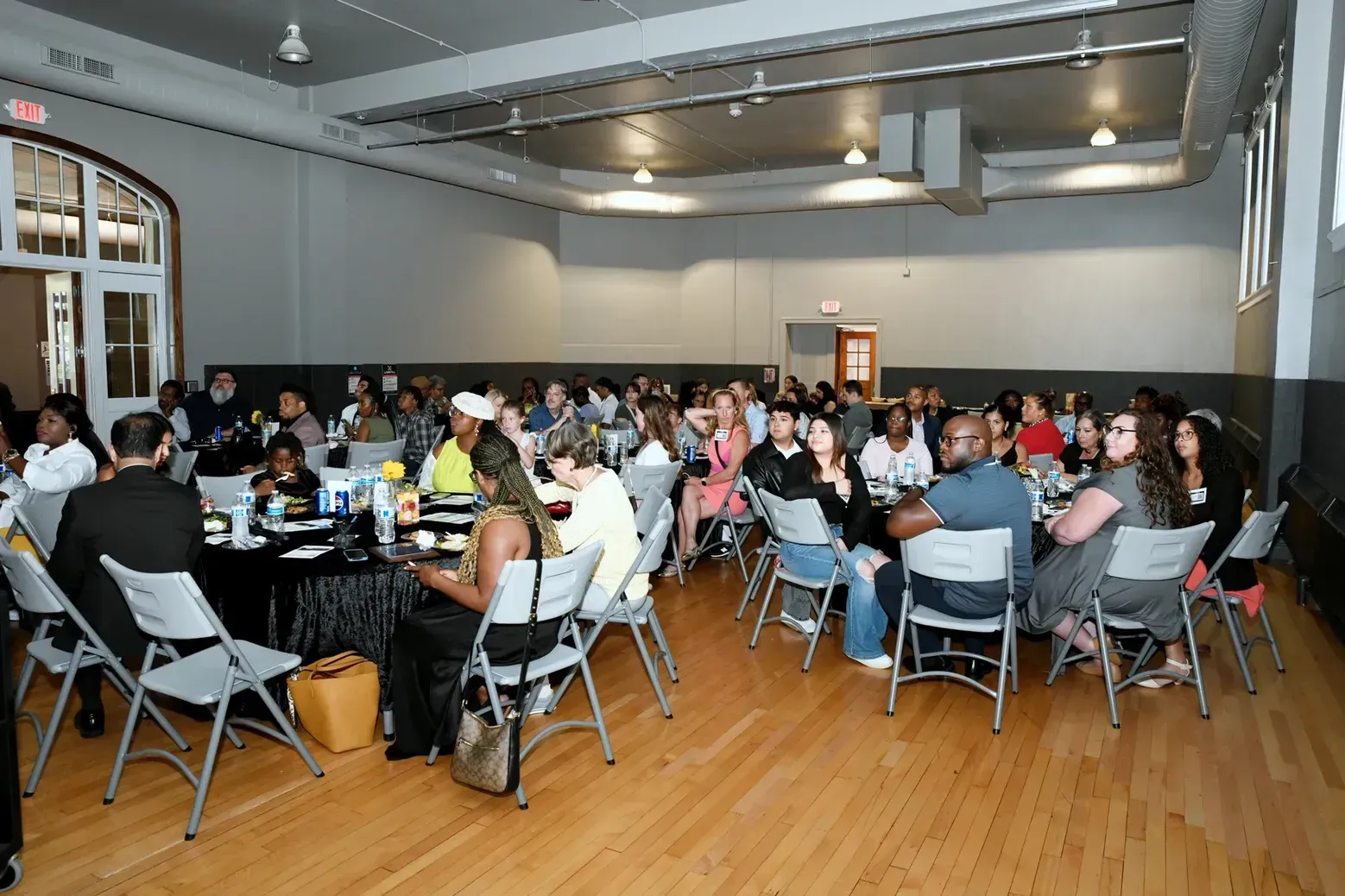 A large group of people are sitting at tables in a large room