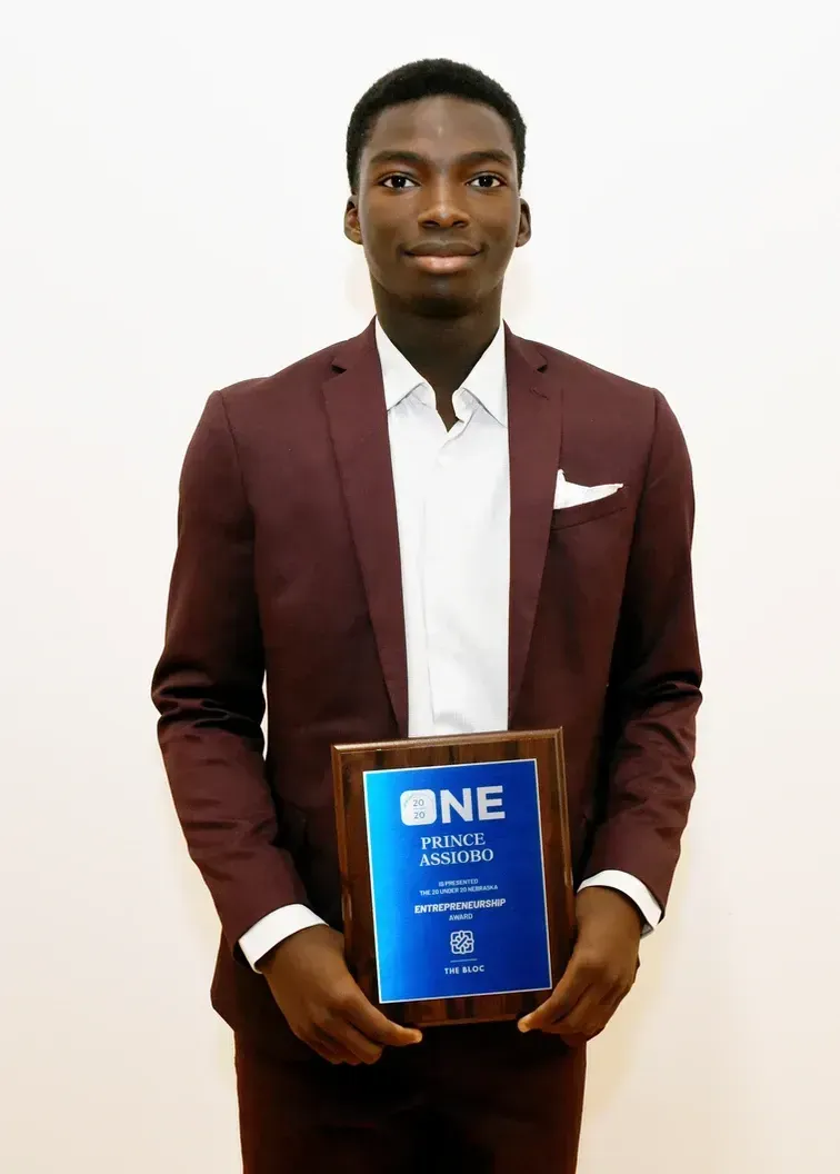 A man in a suit is holding a plaque that says one.