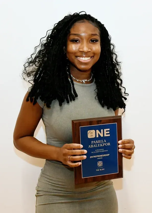 A woman is holding a plaque that says one on it