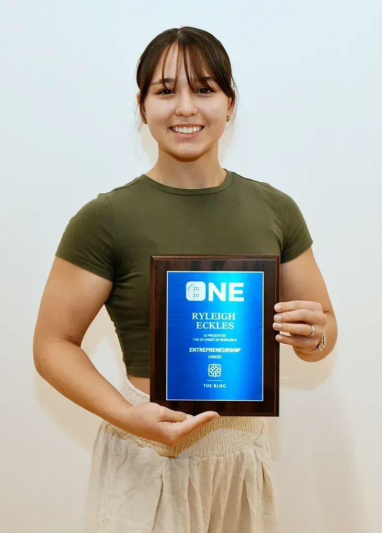 A woman is holding a plaque that says one on it