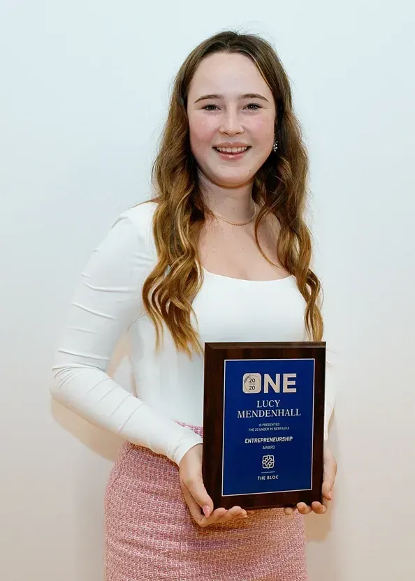 A young woman is holding a plaque that says one on it.