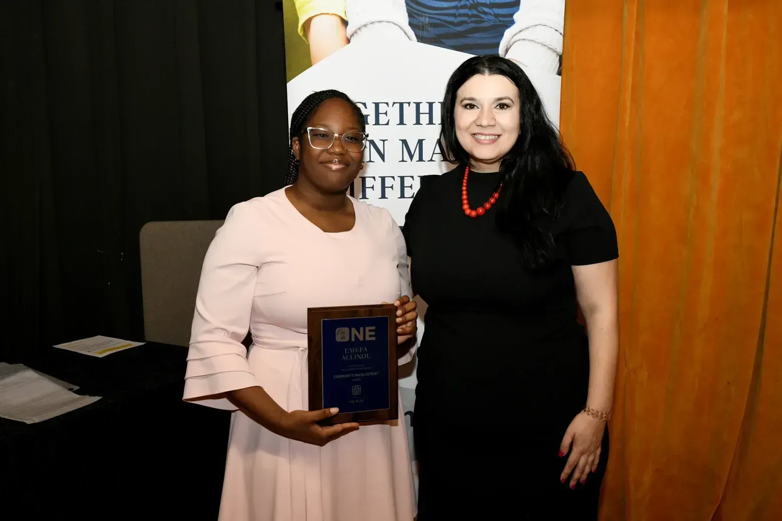 Two women are standing next to each other holding a plaque.
