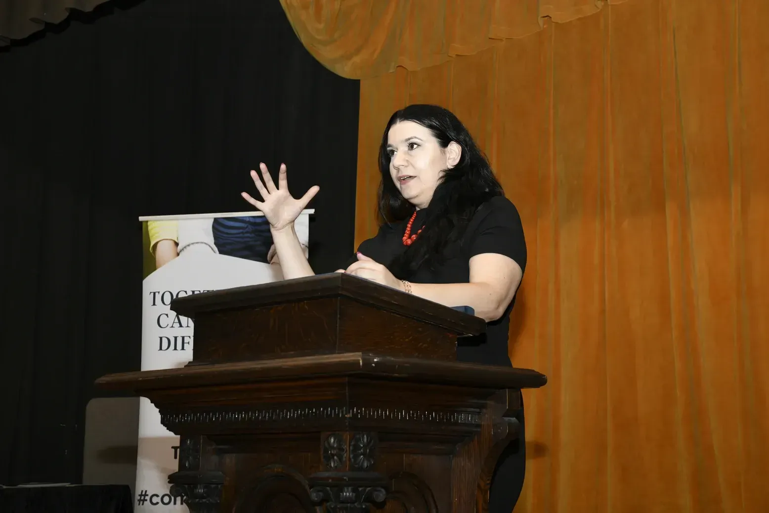 A woman is standing at a podium giving a speech