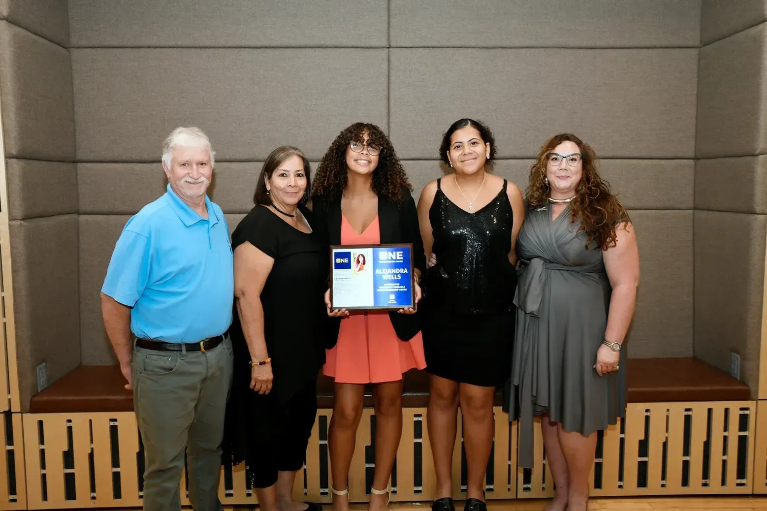 A group of people standing next to each other holding a certificate
