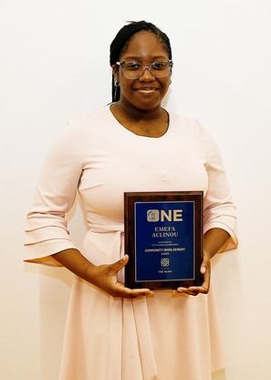 A woman in a pink dress is holding a plaque in her hands.