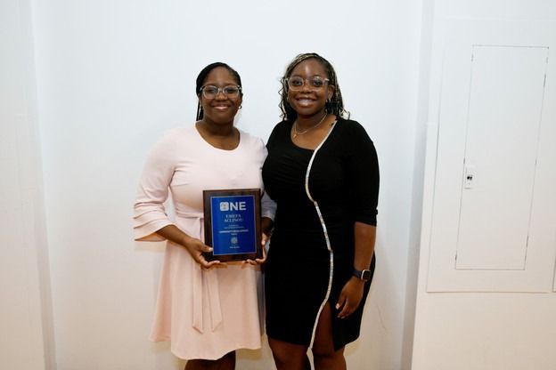 Two women are standing next to each other holding a plaque.