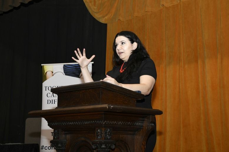A woman is standing at a podium giving a speech
