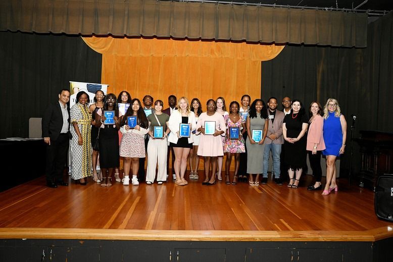 A group of people are posing for a picture on a stage.