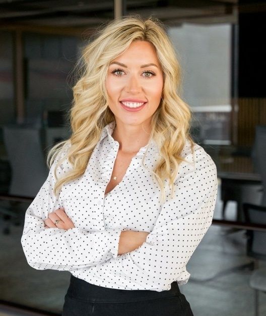 A man and a woman are sitting on a dock overlooking a lake.