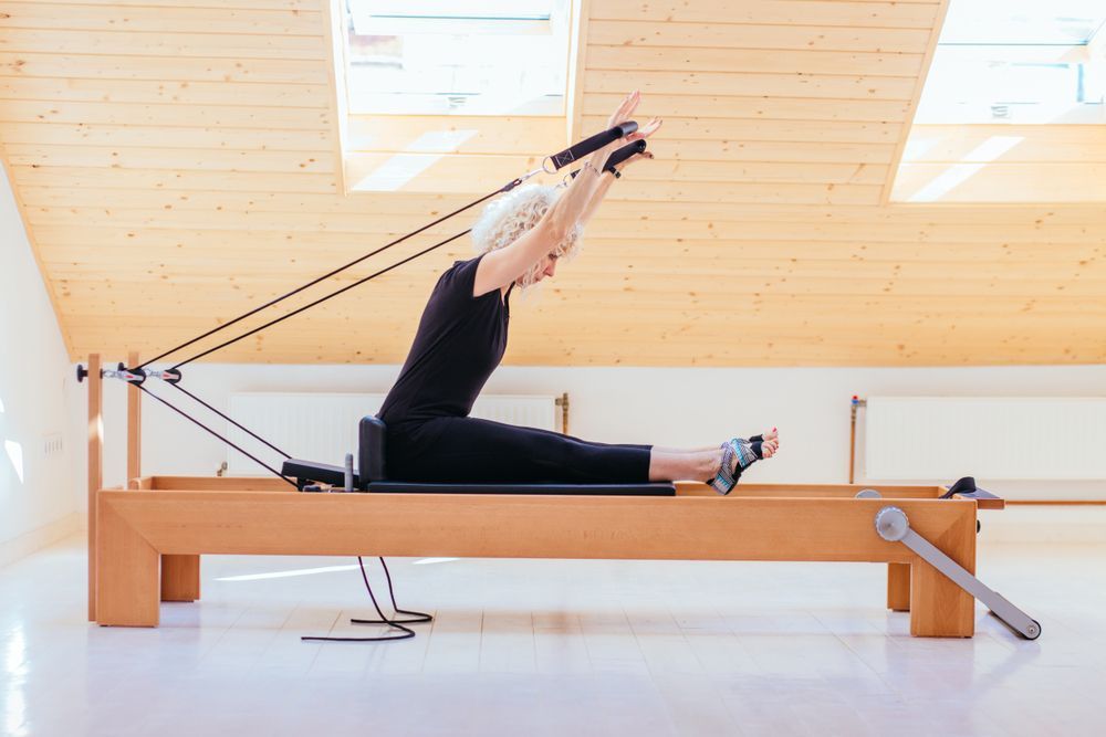 Woman Doing Pilates on a Reformer Machine — Forerunner Physio In Taree, NSW