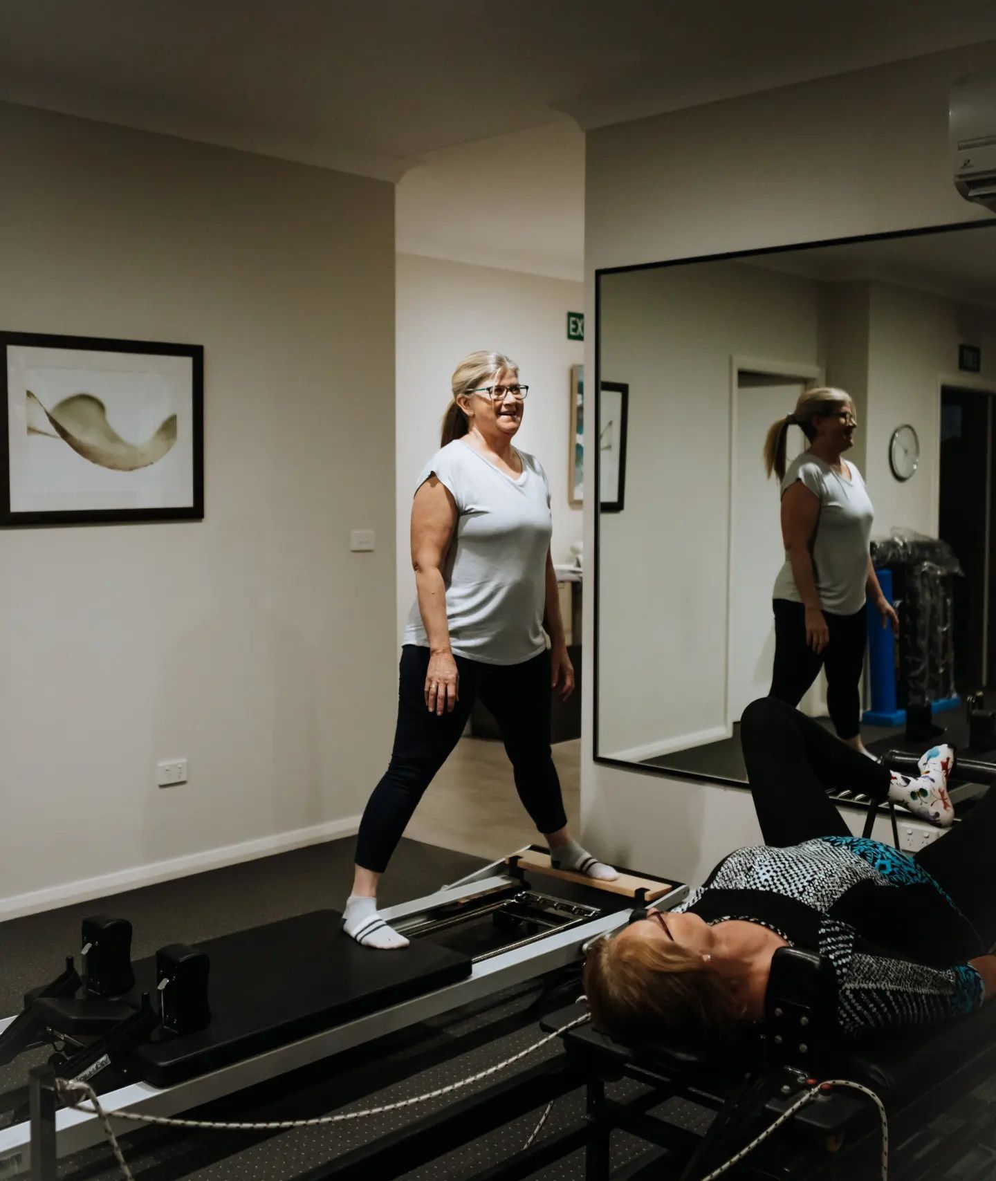 Woman Standing on a Pilates Reformer — Forerunner Physio In Taree, NSW