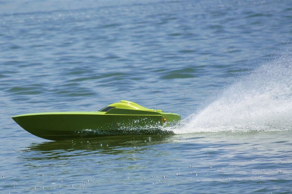 Green RC Boat Speeding Across Water, Creating A Wake And Spray — Midtown Hobbies In Lismore, NSW