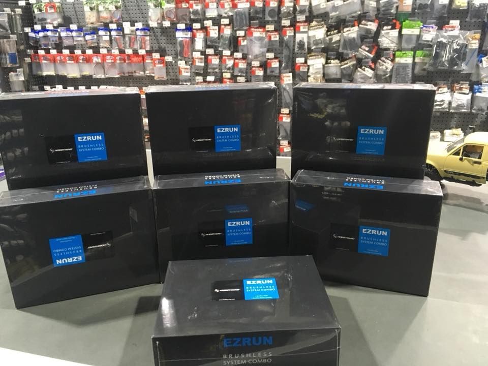 Seven Black Boxes With Blue Labels, Likely Electronics, Stacked In A Store Setting — Midtown Hobbies In Lismore, NSW